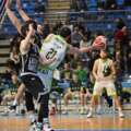 Player wearing white number 21 protects the basketball between two black-clad defenders